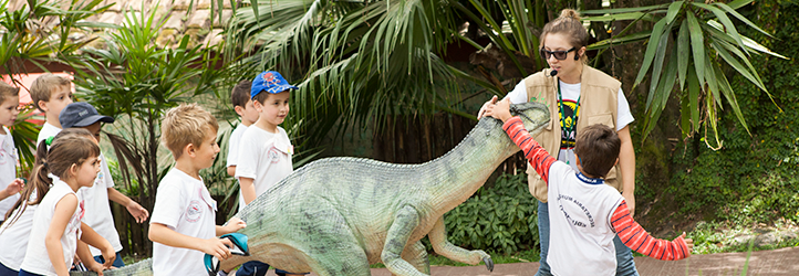 Atrações da Vila Encantada: foto de crianças brincando com um modelo de dinossauro